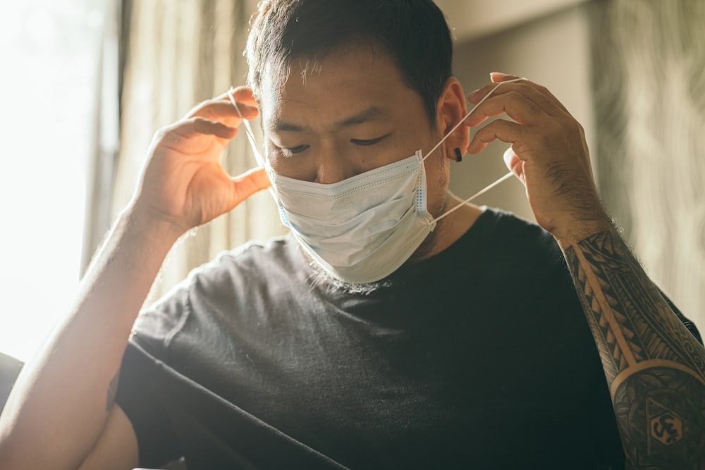 man in black crew neck shirt with white face mask