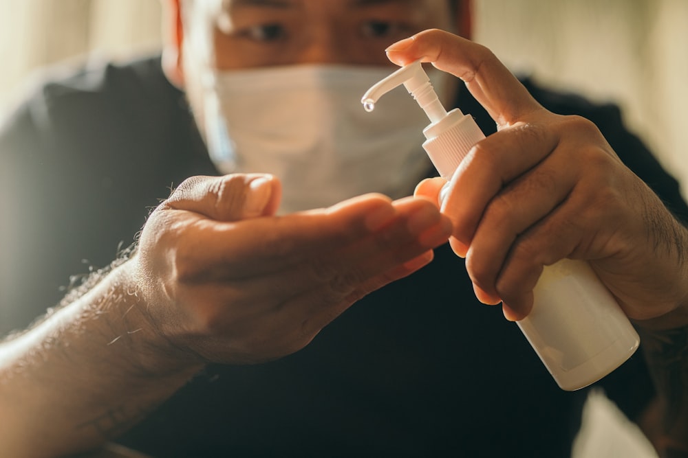 person holding white plastic tube