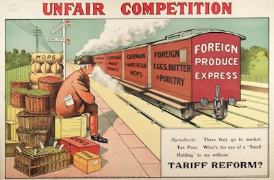 A railway scene depicting a freight train labeled 'Foreign Produce Express' carrying goods like 'Foreign Fruit', 'Chicago Meat Trust', 'German & American Hops', and 'Foreign Eggs, Butter & Poultry'. A man, wearing a suit and bowler hat with a paper that says 'Rate on Demand', sits on crates beside baskets labeled 'Hops' and 'Eggs'. A signpost with 'Foreign' and 'English' highlights economic themes. The caption below the image reads: 'Agriculturist: There they go to market, Tax Free. What’s the use of a “Small Holding” to me without Tariff Reform?'