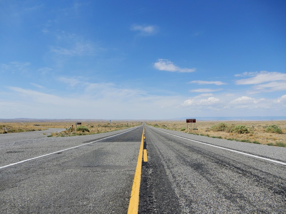 Carretera de asfalto gris bajo el cielo azul durante el día
