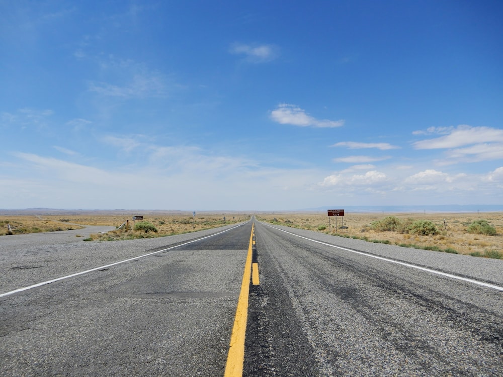 gray asphalt road under blue sky during daytime