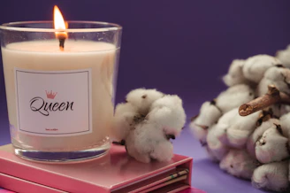 Close-up of a gentle pink candle flickering beside a notebook.