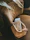 Close-up of a stylish velvet bag resting on a café table with a coffee cup nearby
