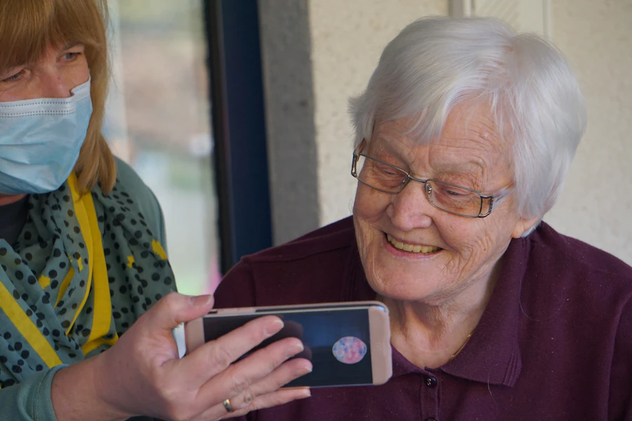 A senior woman at home checking her phone for a medication reminder
