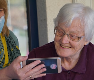 woman in brown button up shirt holding white smartphone