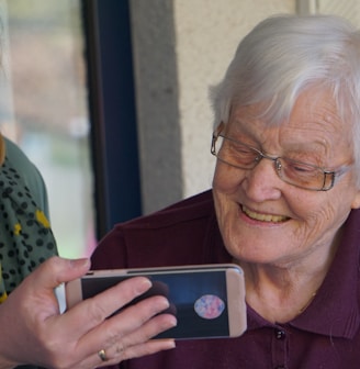 woman in brown button up shirt holding white smartphone