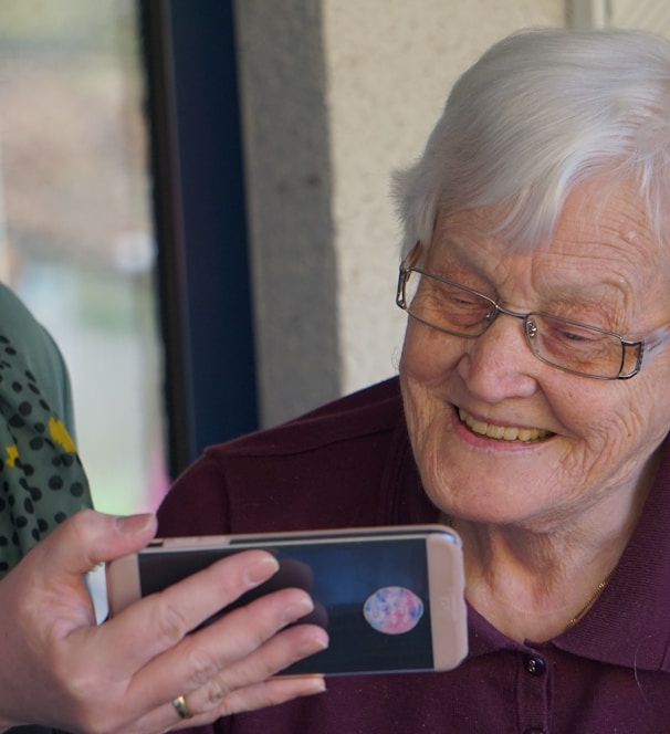 woman in brown button up shirt holding white smartphone