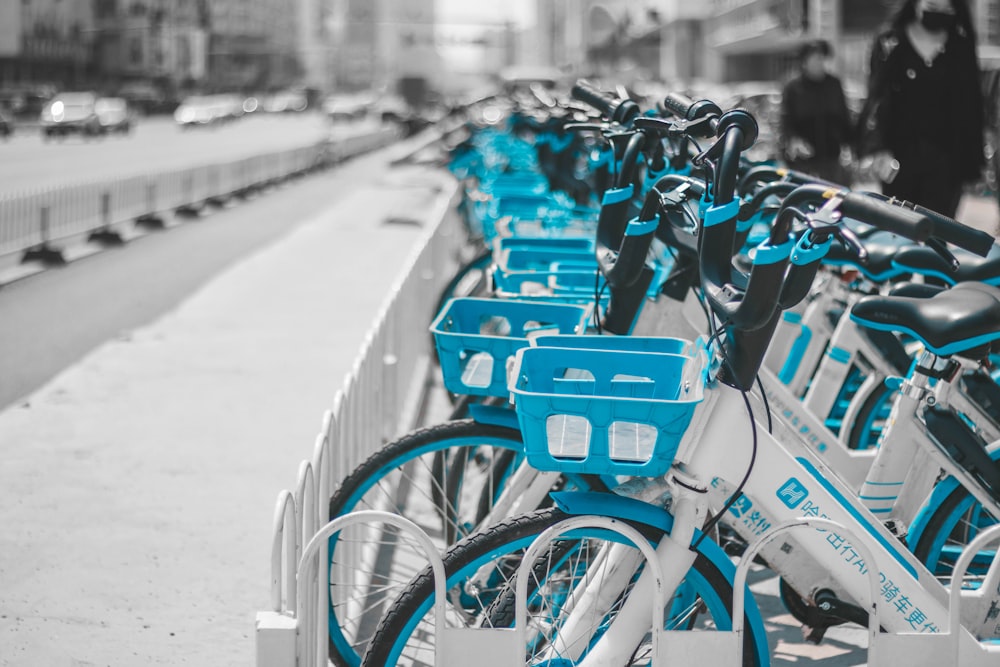 blue and black bicycles parked on sidewalk during daytime