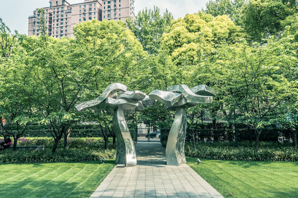 gray concrete statue near green trees during daytime