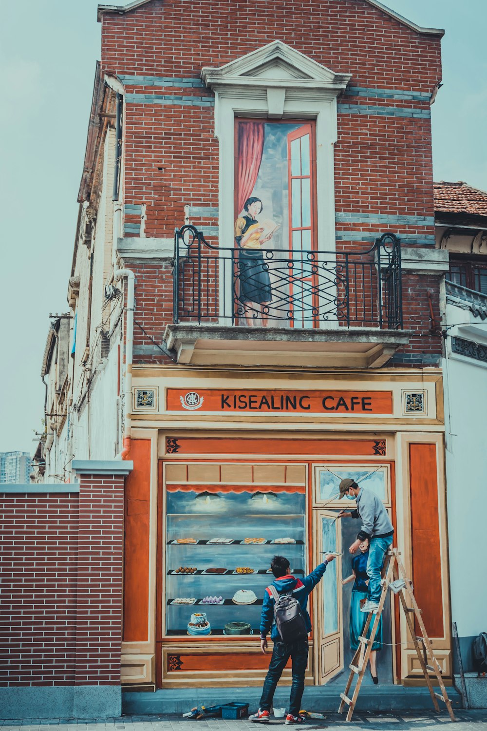 Homme en veste bleue et jean bleu debout à côté d’un bâtiment en briques rouges pendant la journée