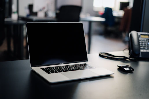 A laptop on a desk with technical support tools nearby.