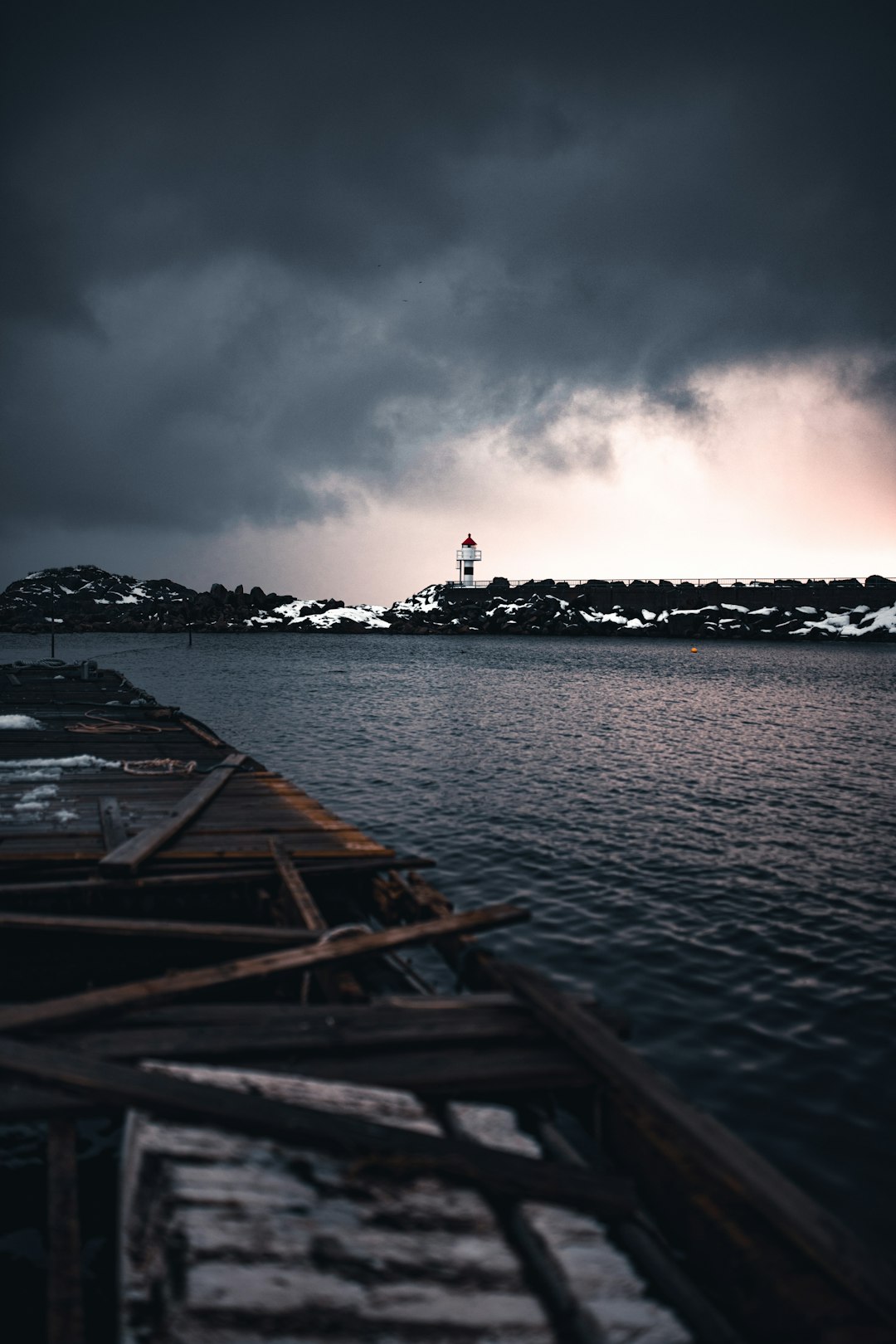 brown wooden dock on body of water under cloudy sky during daytime