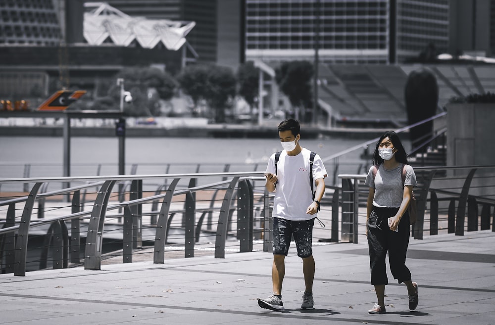 man in white crew neck t-shirt and black shorts standing beside woman in black tank