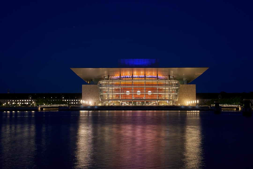 lighted building near body of water during night time