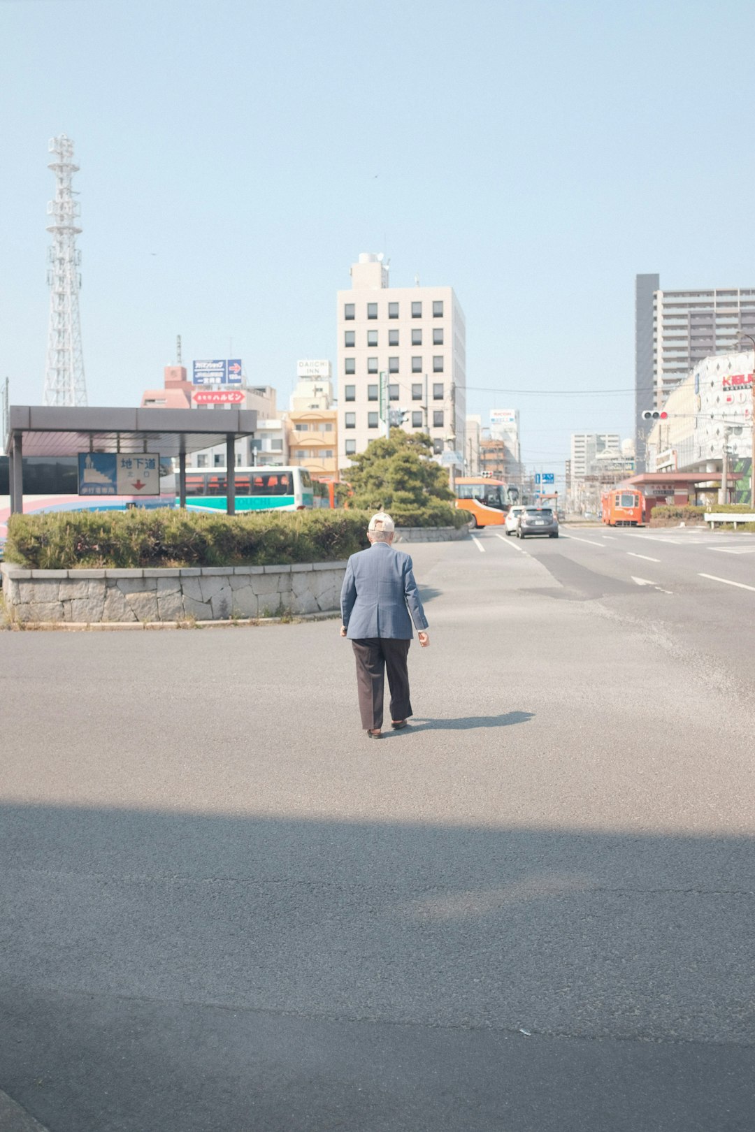 man in white shirt and black pants walking on gray asphalt road during daytime