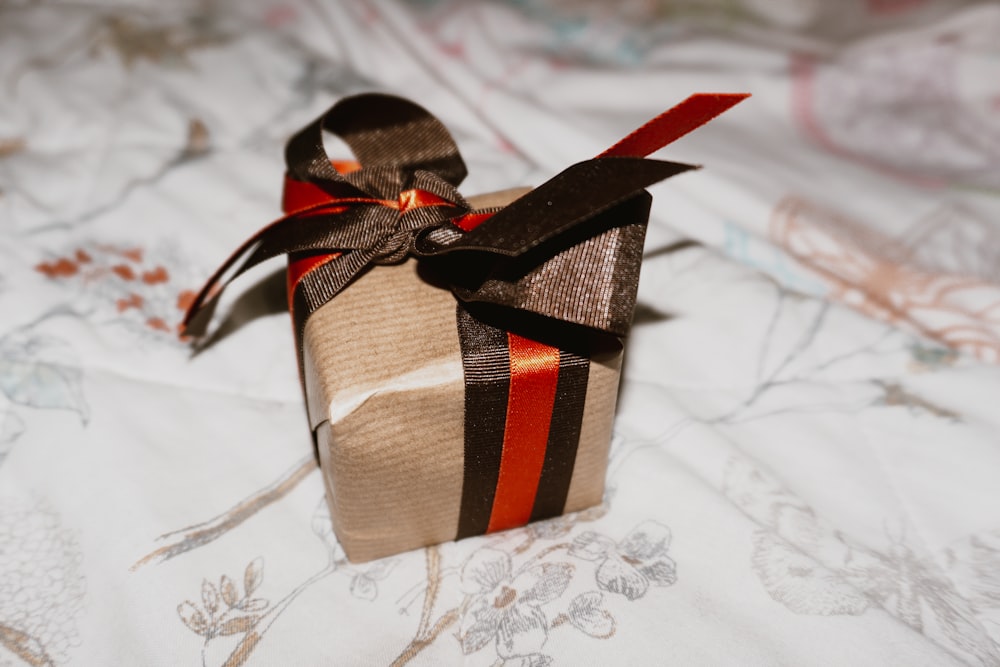 brown and white plaid gift box on white floral textile