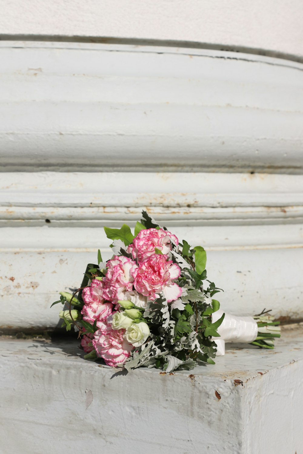 pink and white flowers on white ceramic vase