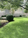 A beautifully landscaped front yard with lush greenery and elegant hardscaping in a Dallas neighborhood.