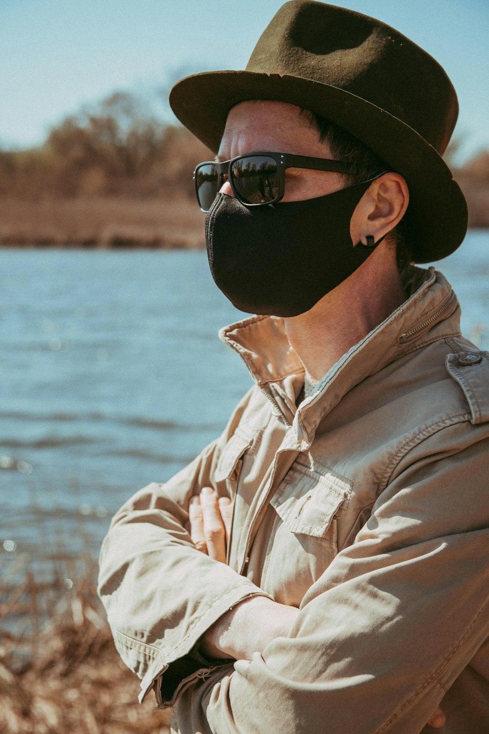 man in brown button up shirt wearing black sunglasses and brown hat