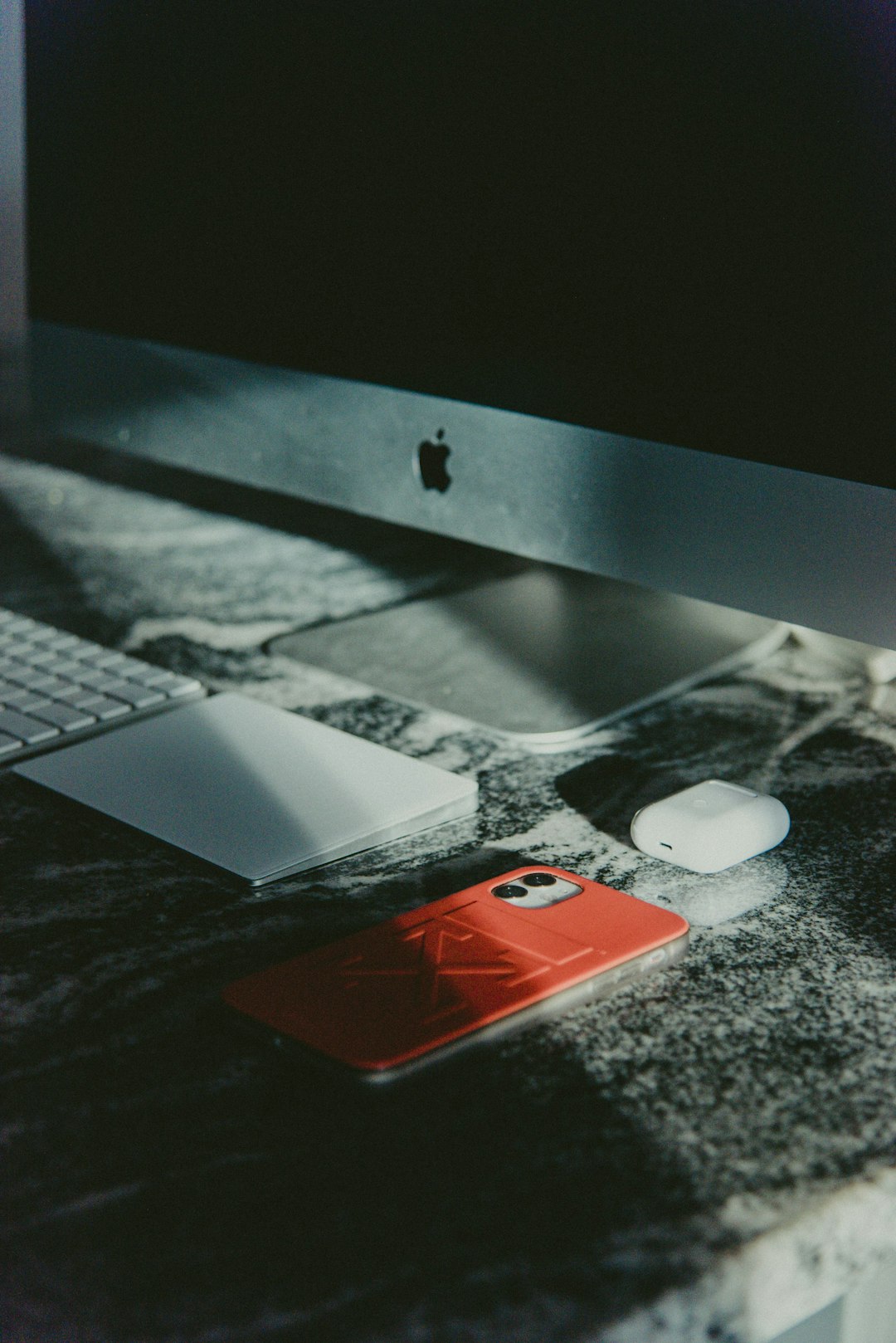 white and red iphone case on black table