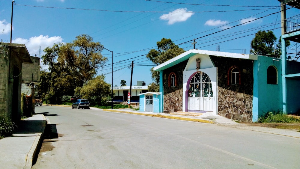 edificio in cemento bianco e verde vicino alla strada durante il giorno