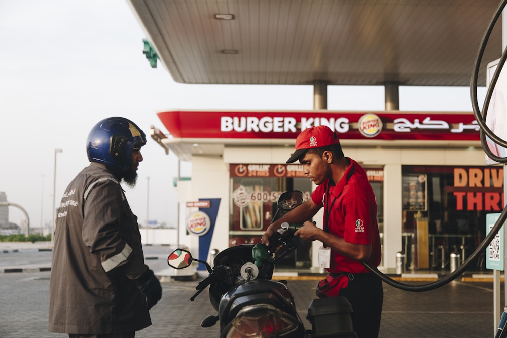 man in red shirt and black pants wearing red helmet riding motorcycle