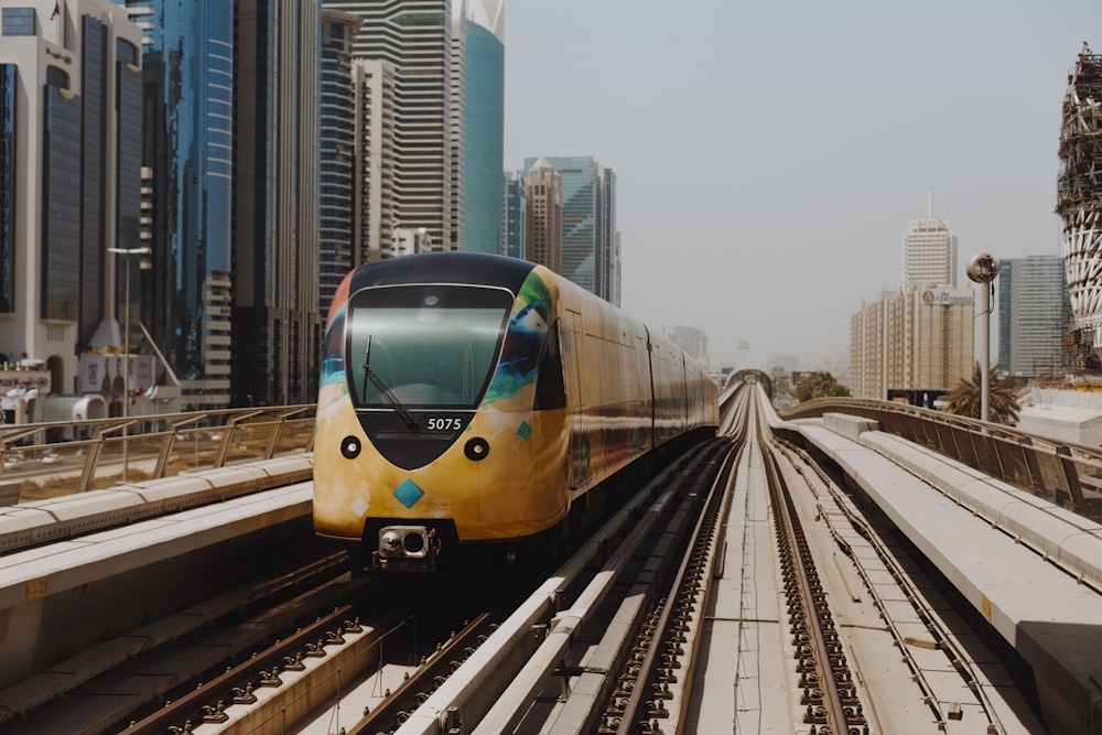 yellow and blue train on rail tracks during daytime