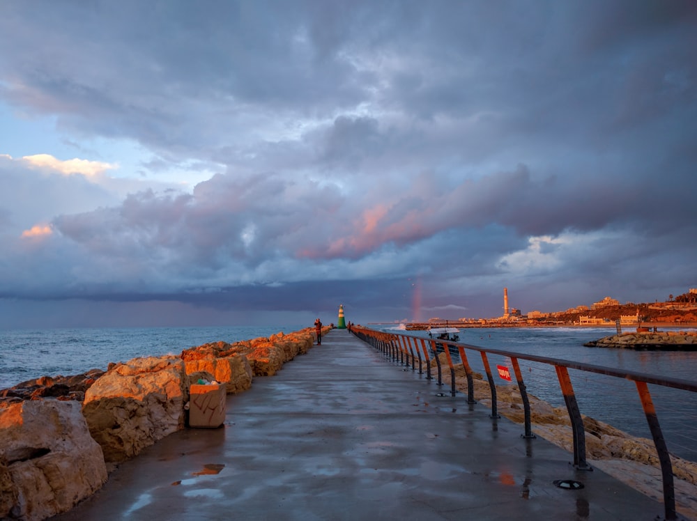 brown wooden dock on sea under cloudy sky during daytime