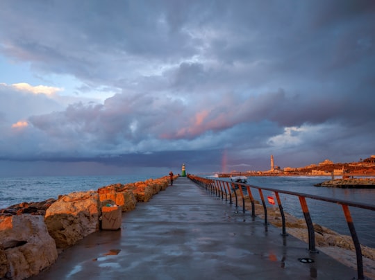 brown wooden dock on sea under cloudy sky during daytime in Tel Aviv Israel