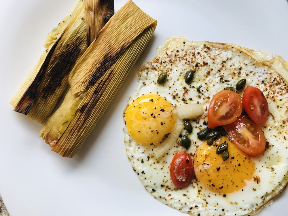 Pain tranché à la tomate et aux légumes verts sur assiette en céramique blanche