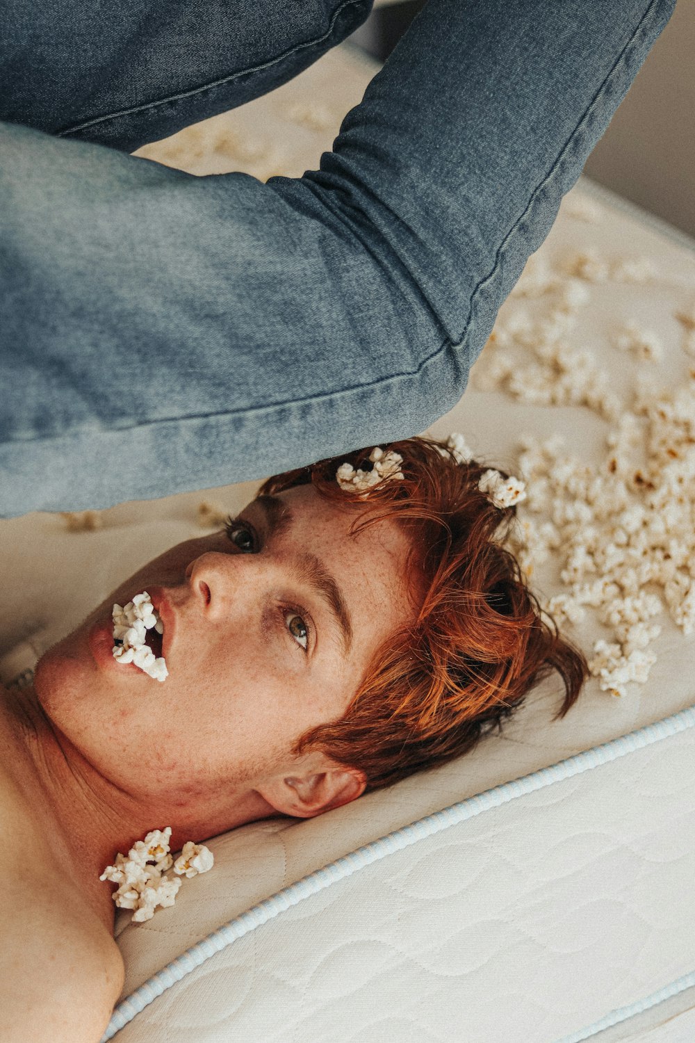 woman in blue denim jacket lying on white bed