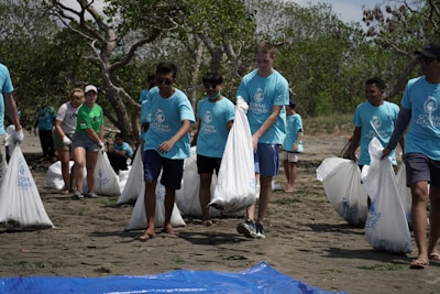Volunteers wearing blue shirts helping organize community events outdoors.