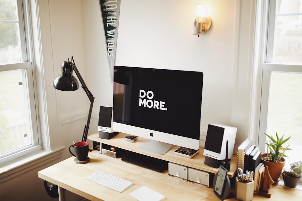 Imac argenté sur bureau en bois marron