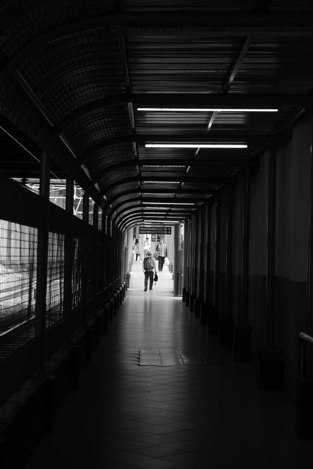 foto in scala di grigi di persone che camminano sul corridoio