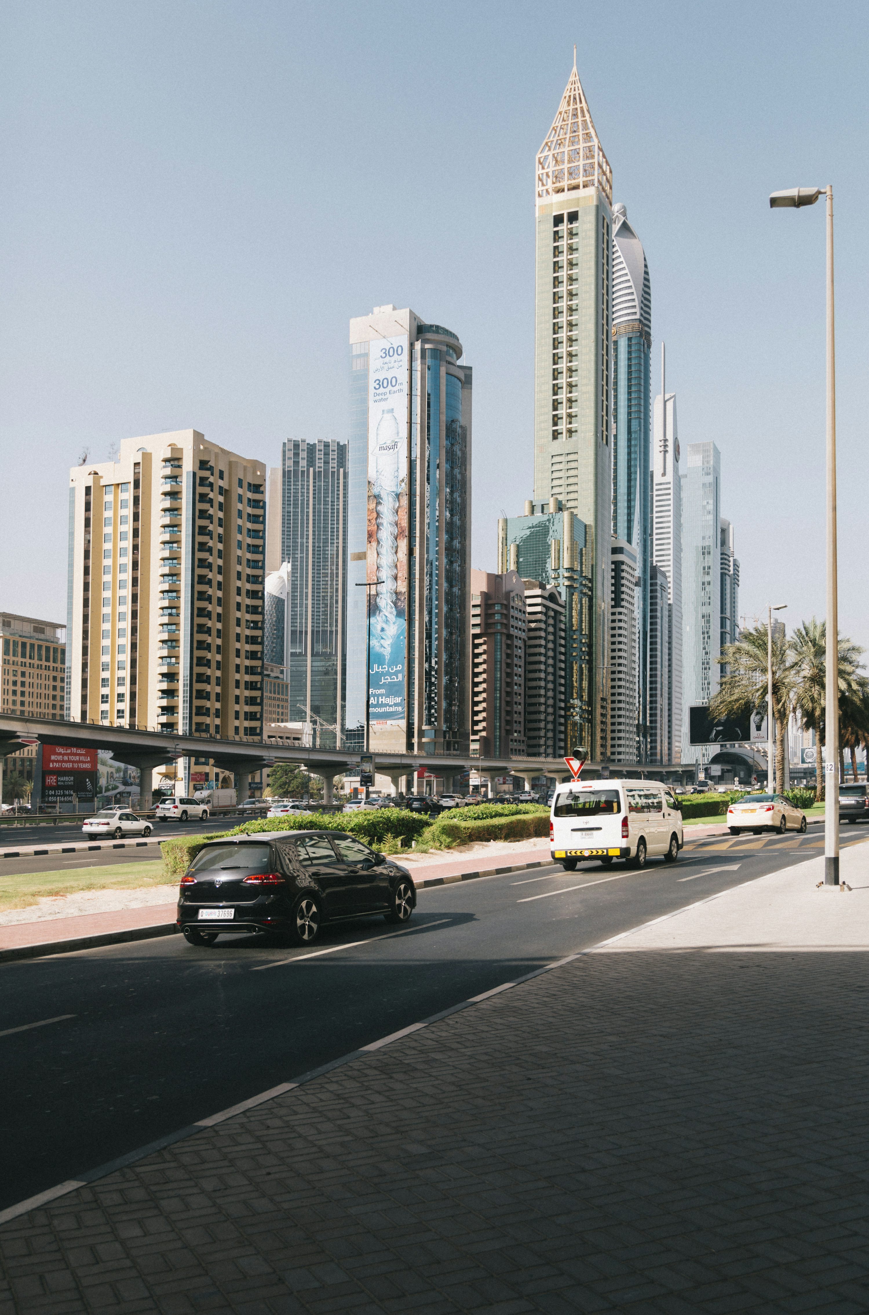 black sedan on road near high rise buildings during daytime