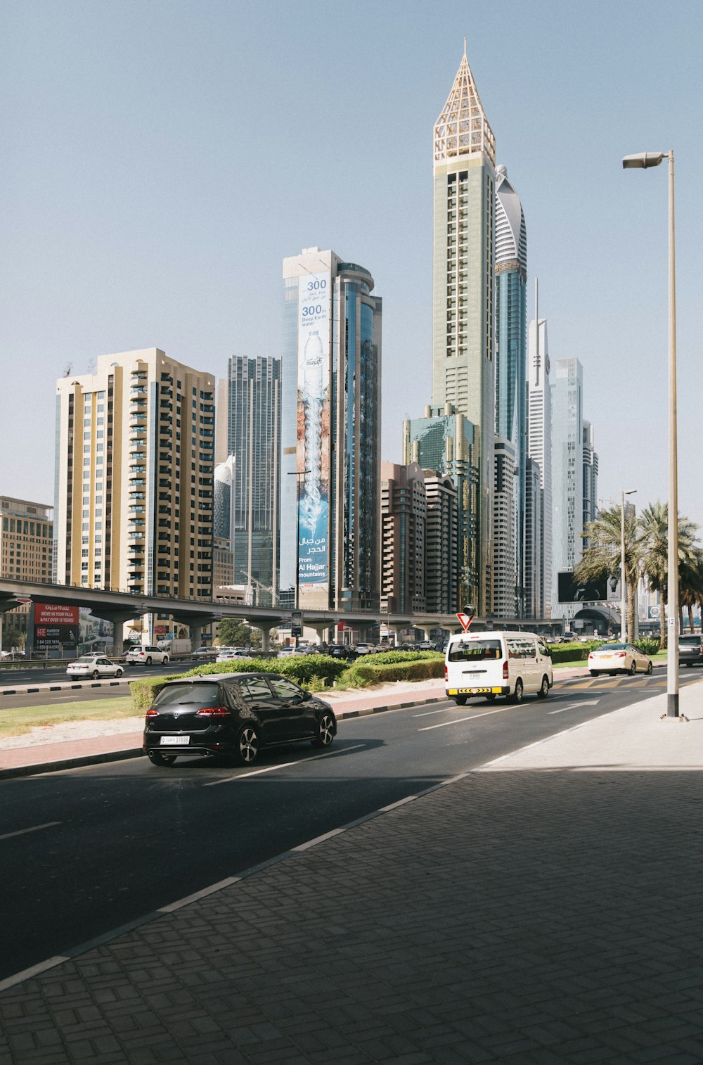 black sedan on road near high rise buildings during daytime