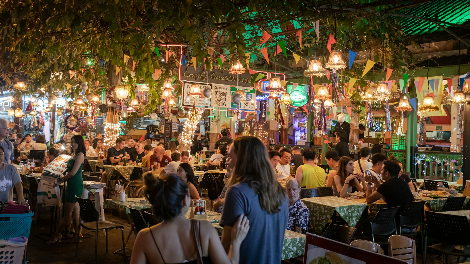 People in an open air restaurant at night time