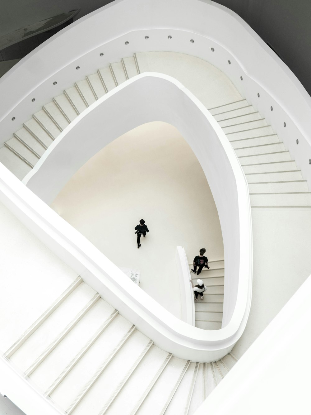 people walking on white spiral staircase