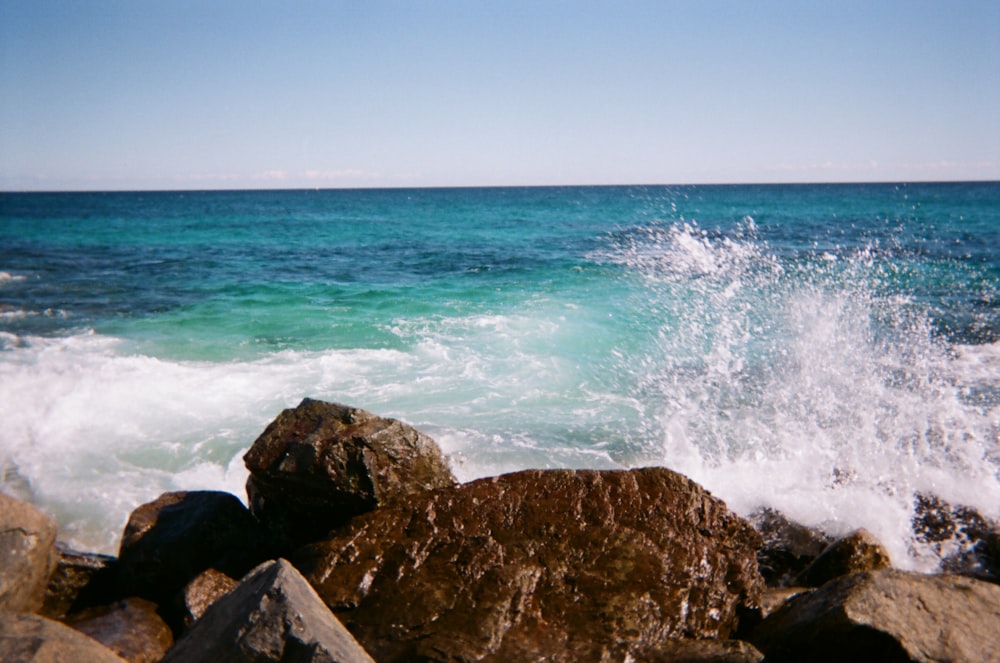 brown rock formation near body of water during daytime