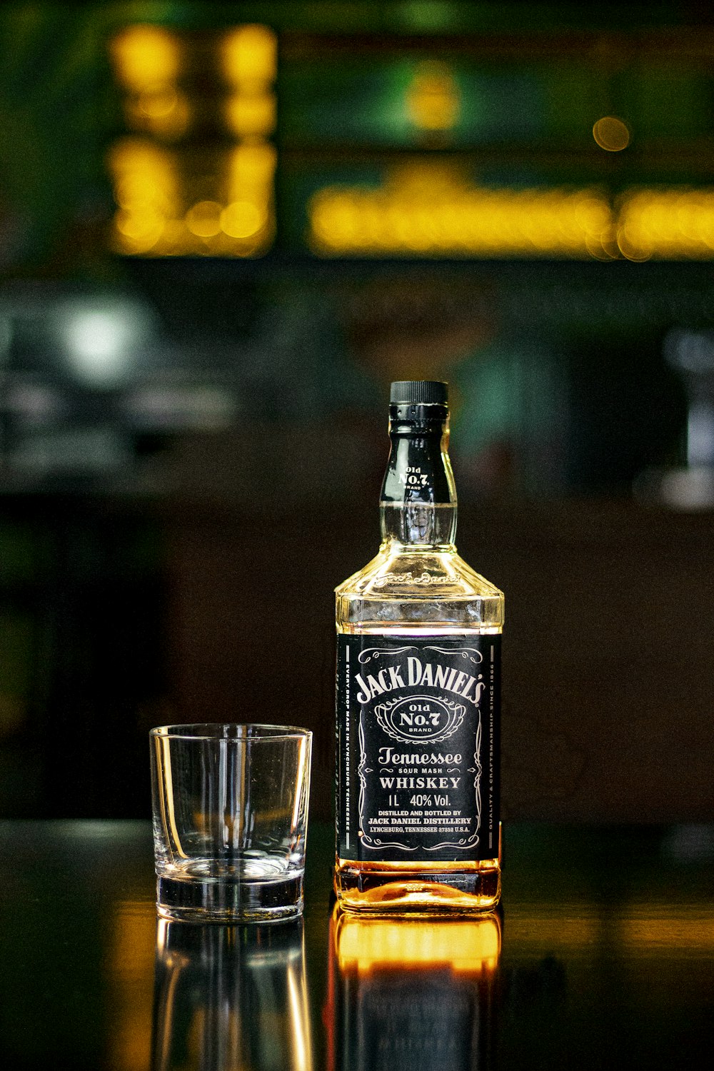 ジャックダニエルオールドNo7テネシーウイスキーボトル横の透明な飲用グラス