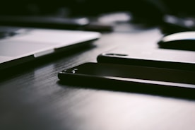 Close-up of a modern laptop and smartphone on a wooden desk