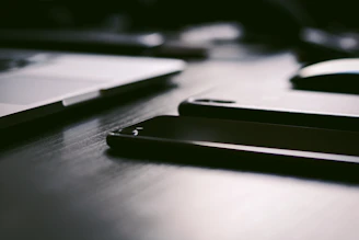 Modern website layout displayed across a laptop and smartphone on a dark desk.