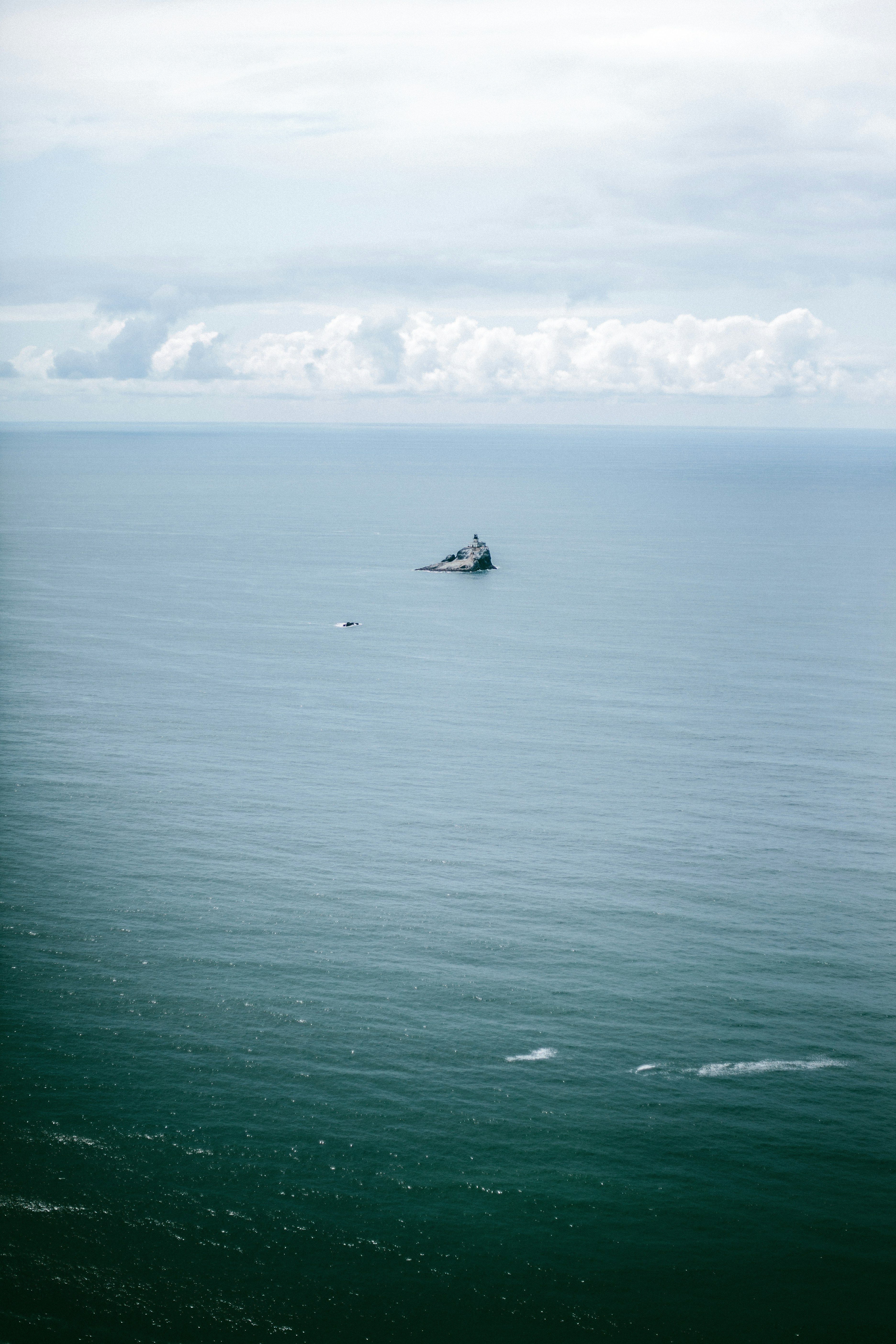 white boat on sea under white clouds during daytime
