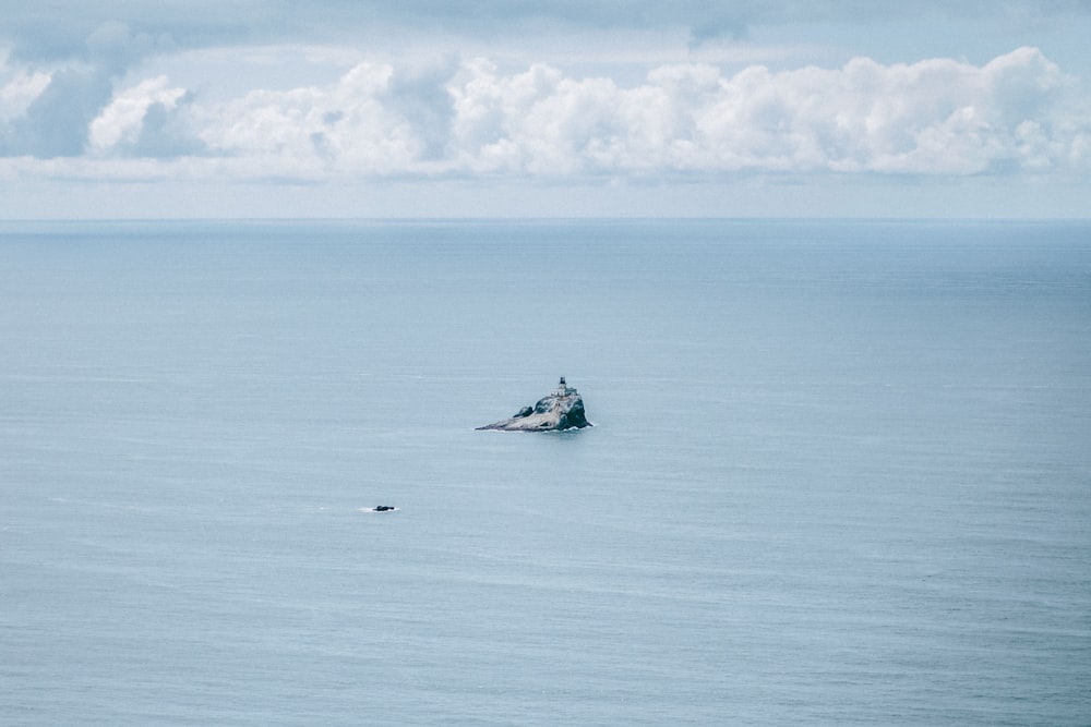 white and black boat on sea under white clouds during daytime