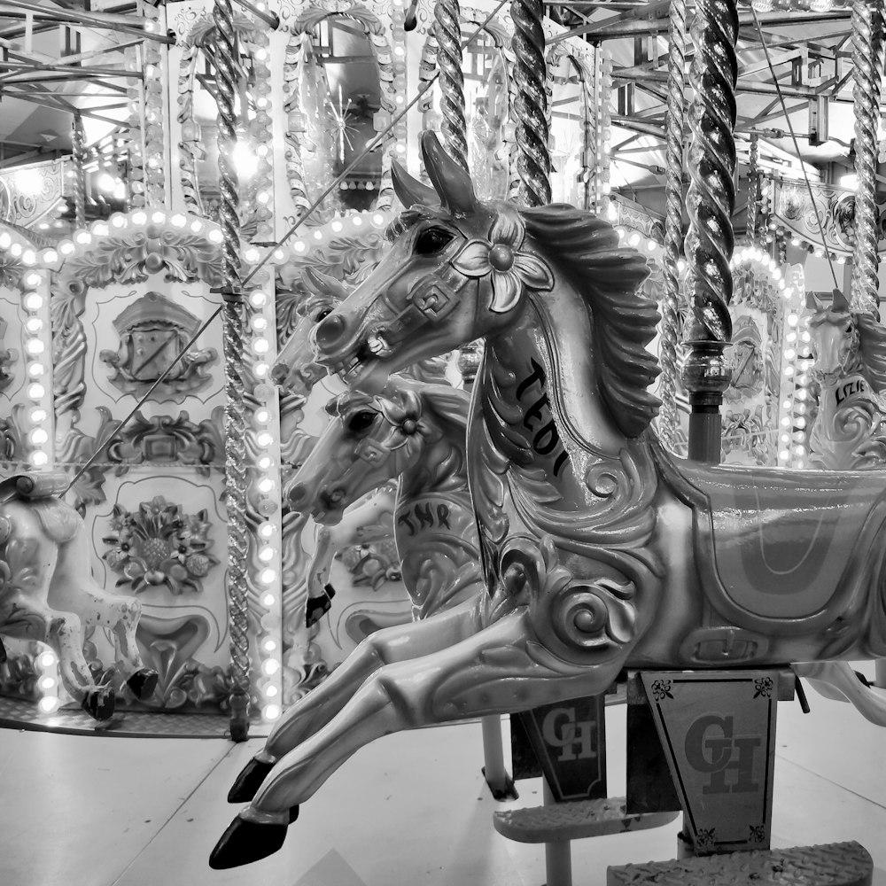 white horse carousel with people
