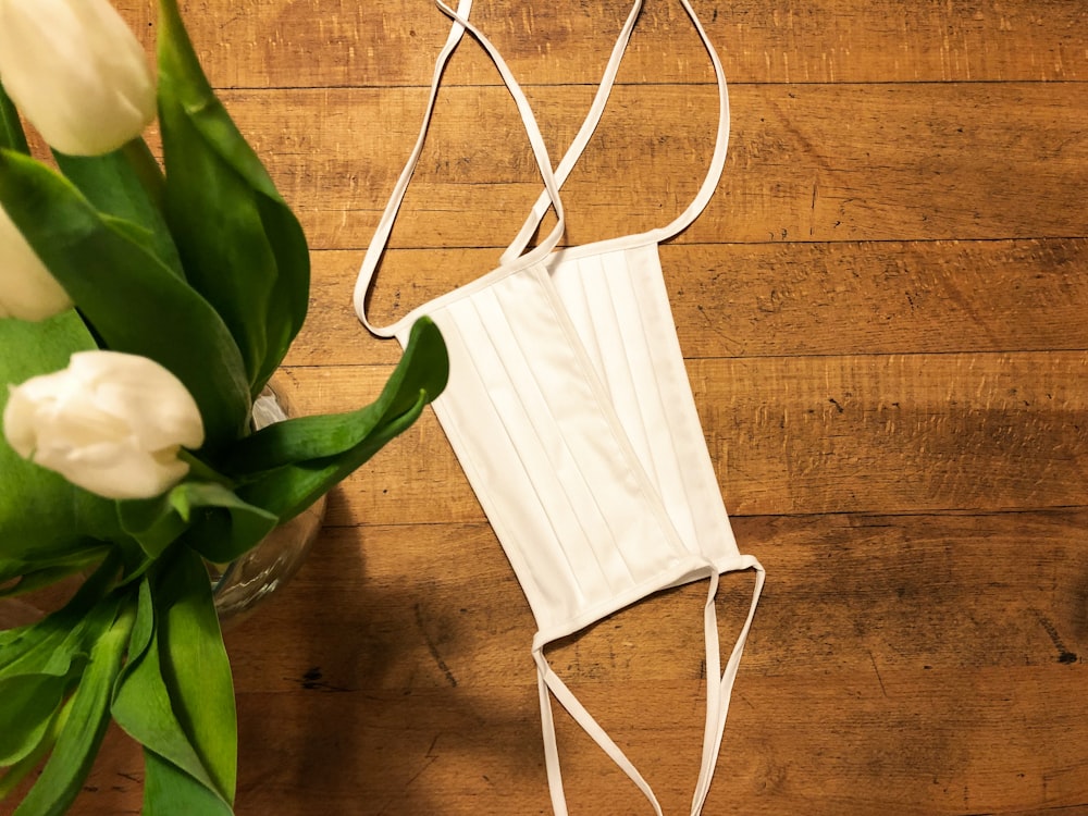 white leather sling bag on brown wooden table