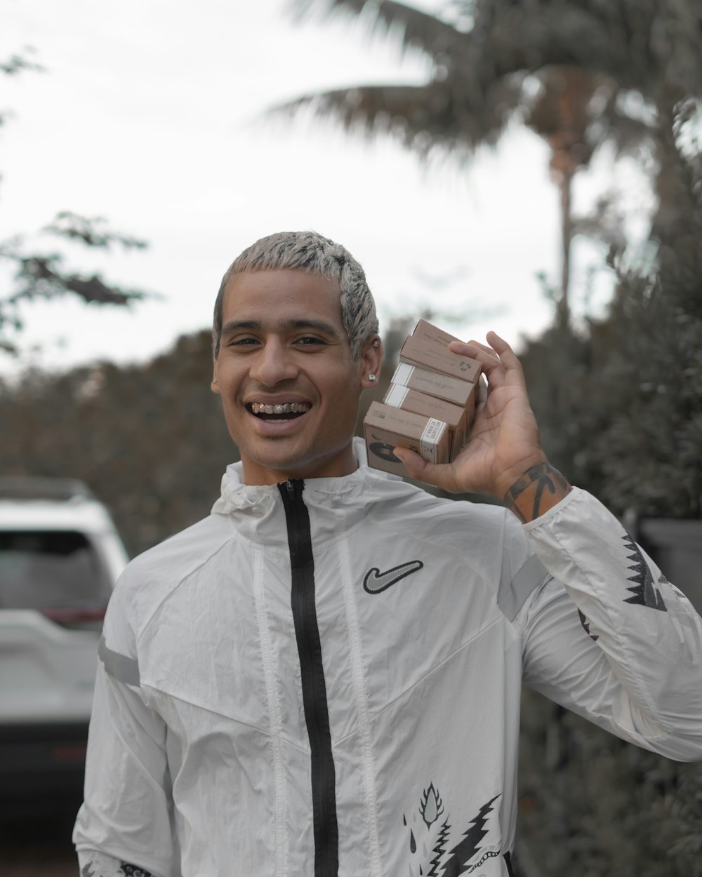 man in white dress shirt holding brown box