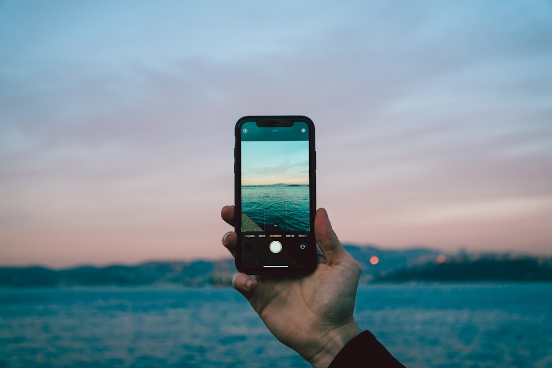 person holding iphone 6 taking photo of sea during daytime