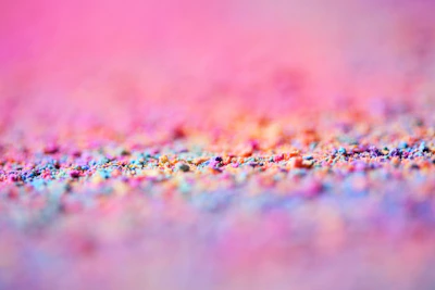 Close-up of vibrant chemical granules spread evenly on a white background.