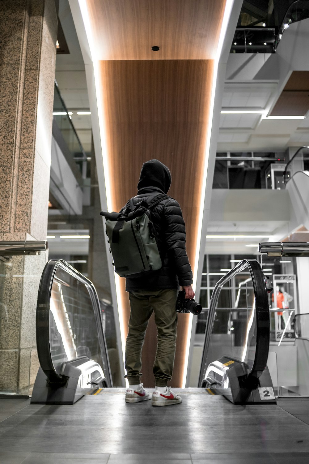 man in black hoodie and black pants walking on hallway